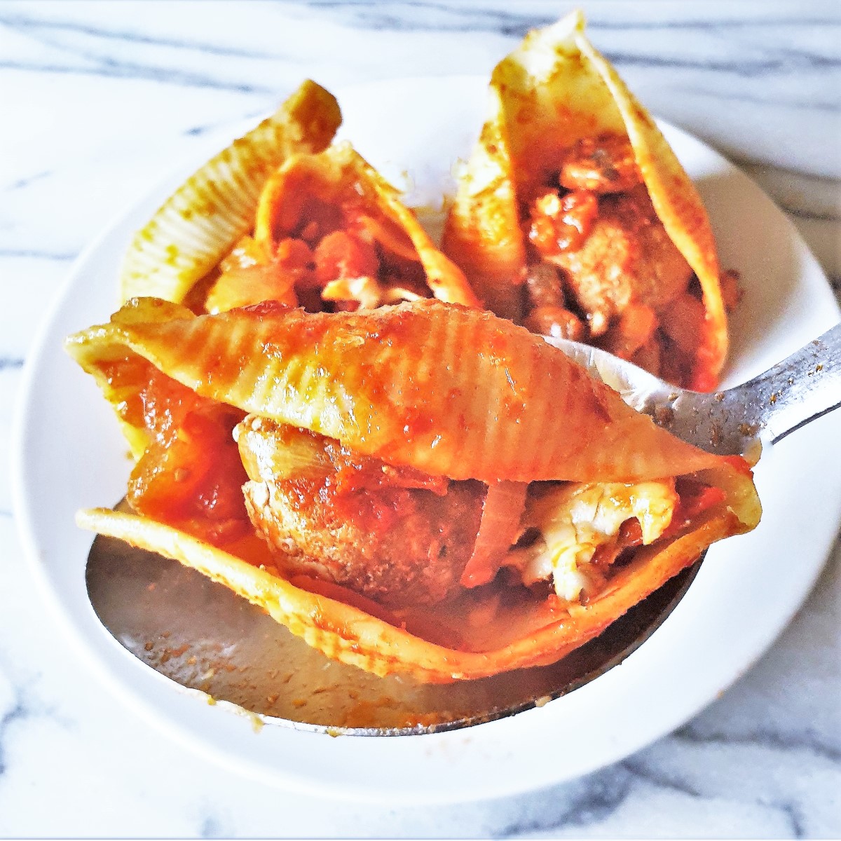 Close up of meatballs in jumbo pasta shells.