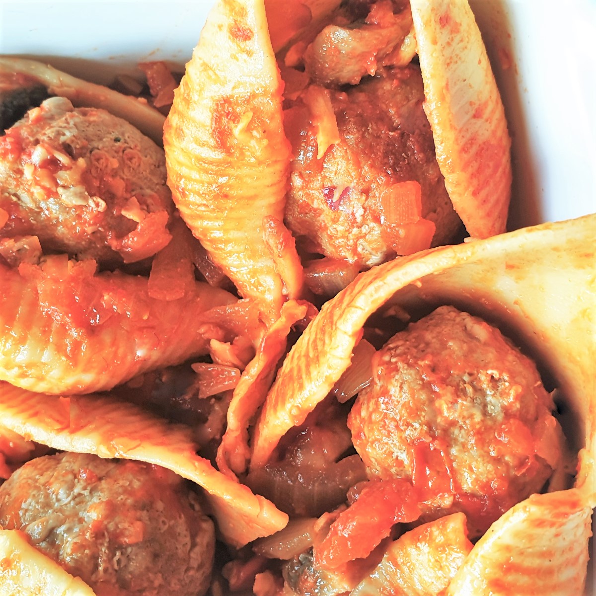 Overhead shot of 4 meatballs in 4 jumbo pasta shells.