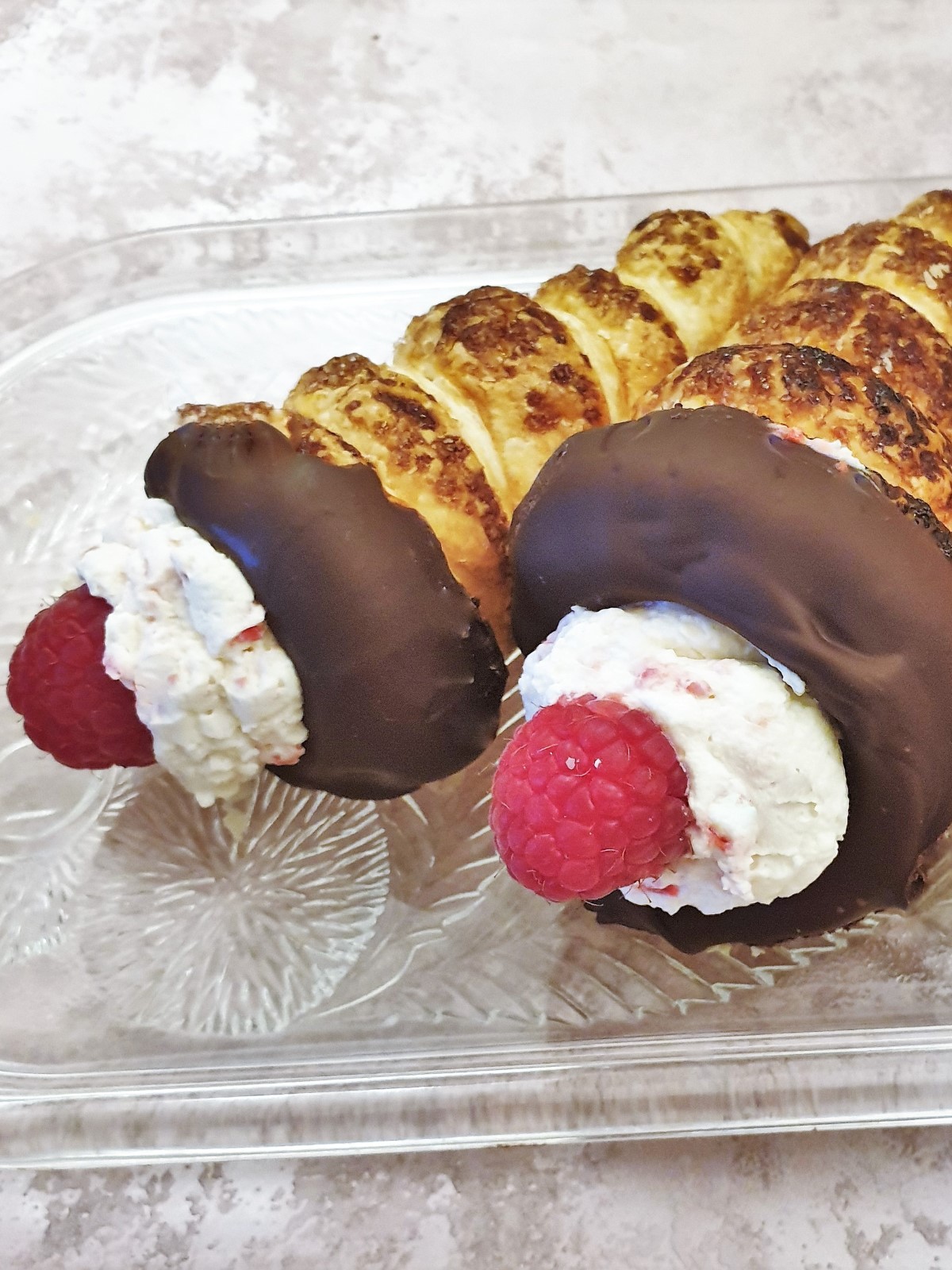 Closeup of 2 cream horns on a plate.