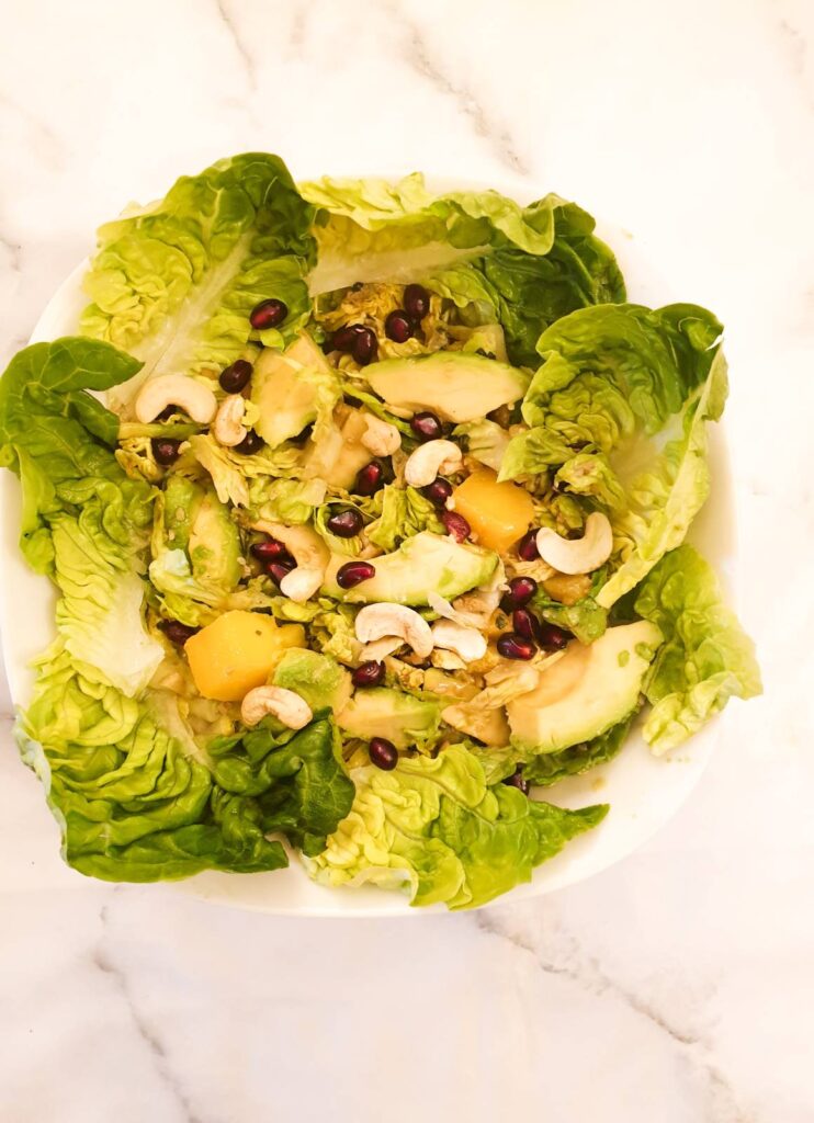 A mango and avocado salad garnished with lettuce leaves.