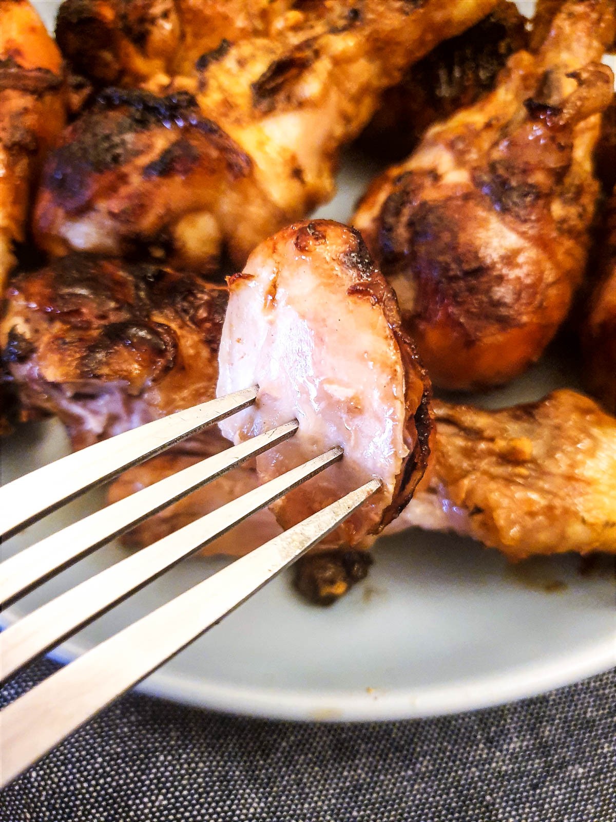 A piece of chicken on a fork showing the juicy texture.
