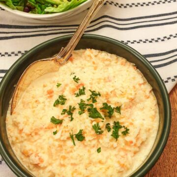 A dish of creamy coleslaw garnished with fresh parsley.