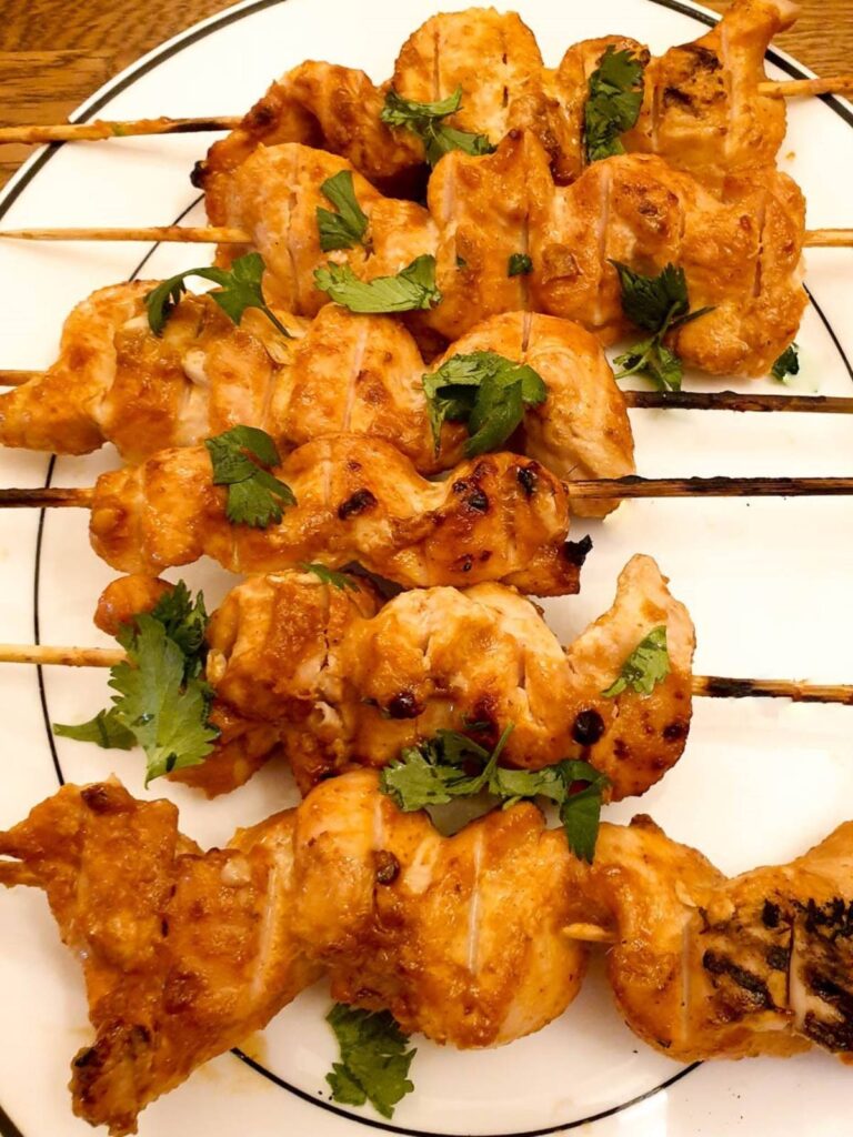 Close up of chicken satay skewers.