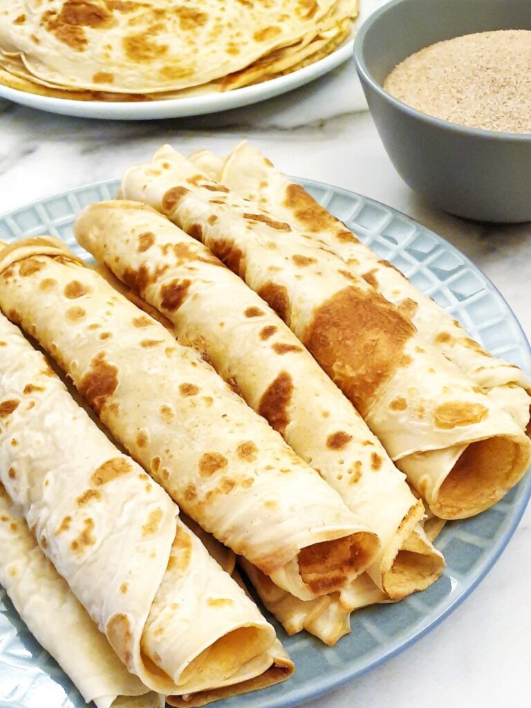 Rolled pancakes on a plate.