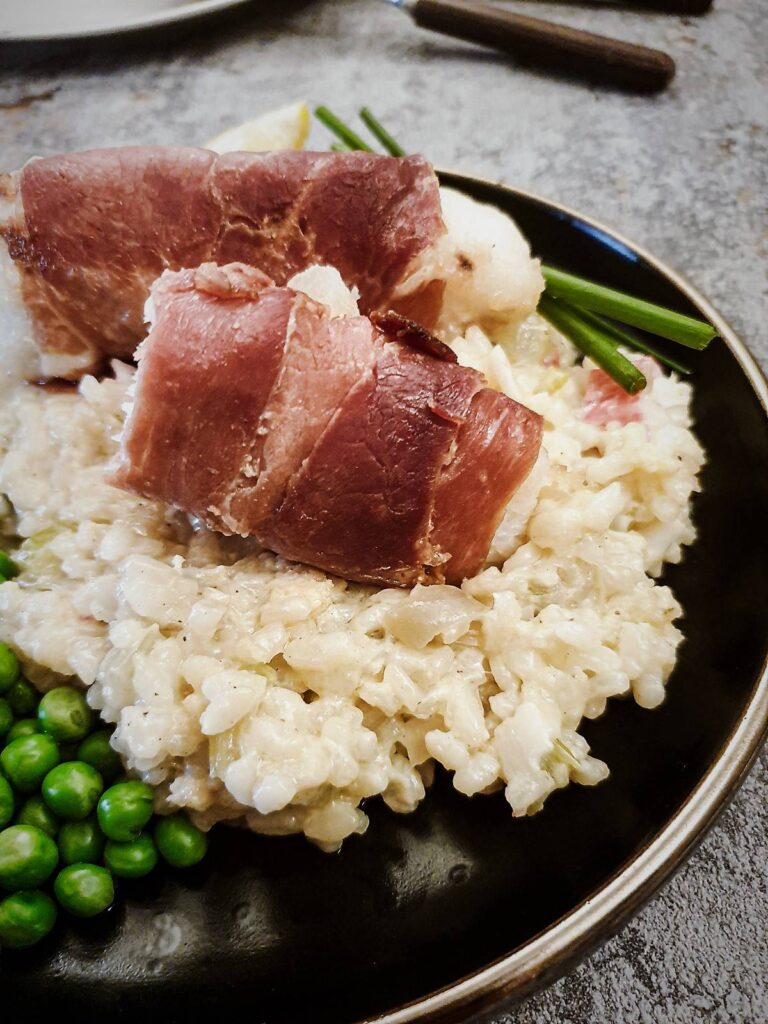 Fillets of monkfish wrapped in serrano ham on a bed of lobster risotto.