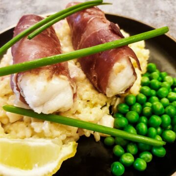 Closeup of two monkfish fillets wrapped in serrano ham.
