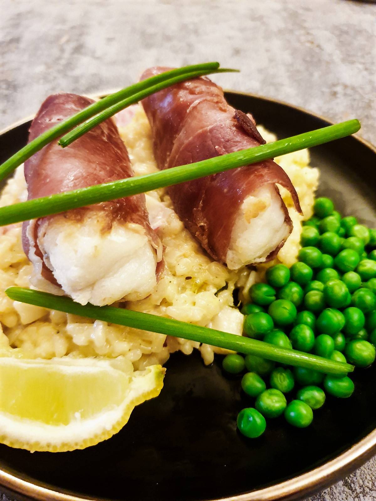 Closeup of two monkfish fillets wrapped in serrano ham.