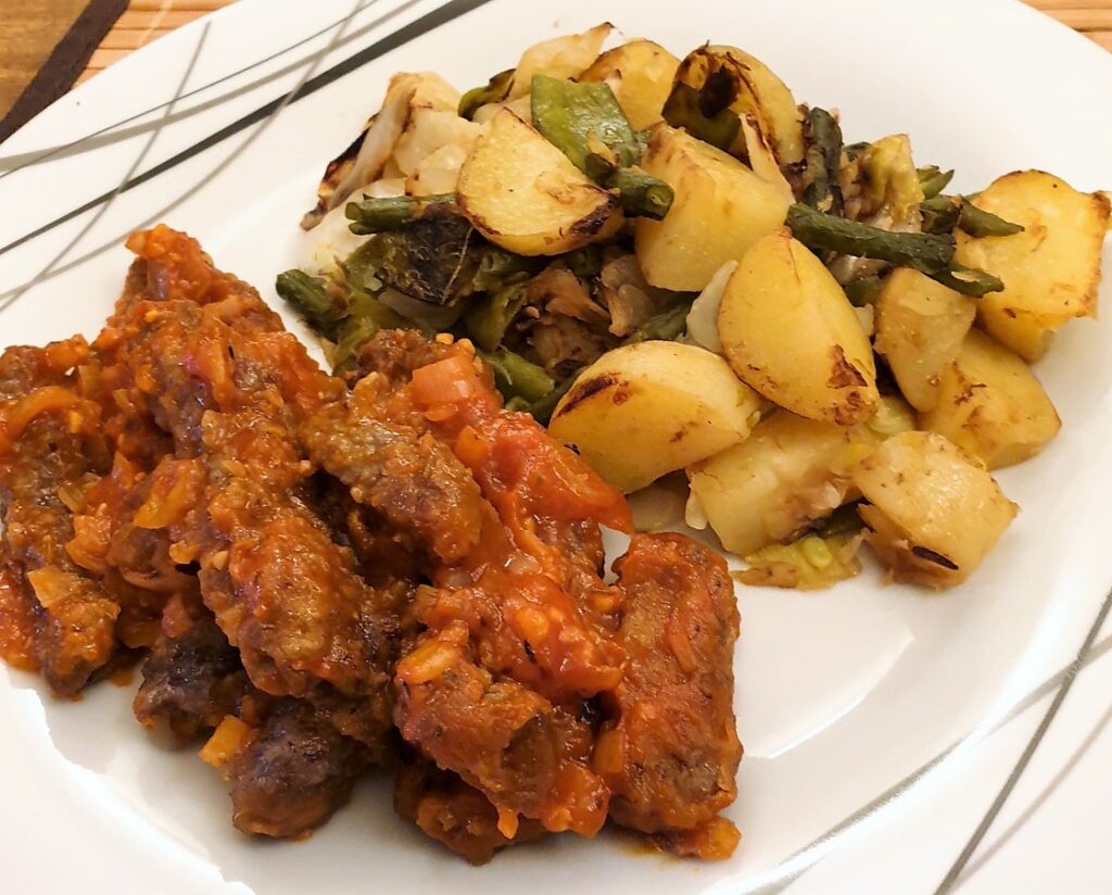 Steak fingers in marinara sauce with a side helping of bubble and squeak.