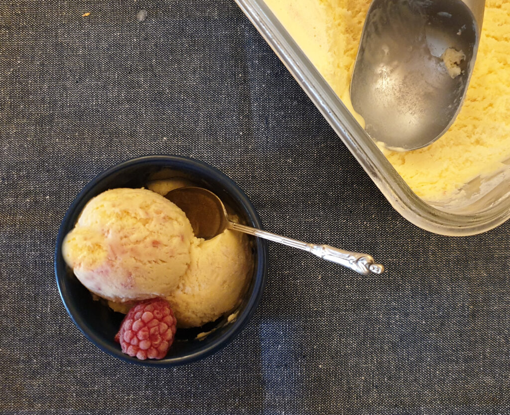 A bowl of raspberry ripple ice cream next to the a dish of frozen ice cream.