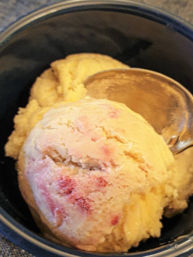 A scoop of homemade raspberry ripple ice cream in a dish.