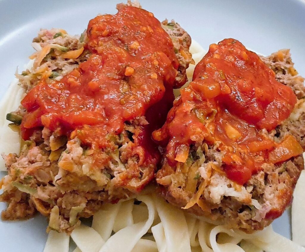 Slices of meatloaf on a bed of pasta, smothered with delicious marinara sauce.