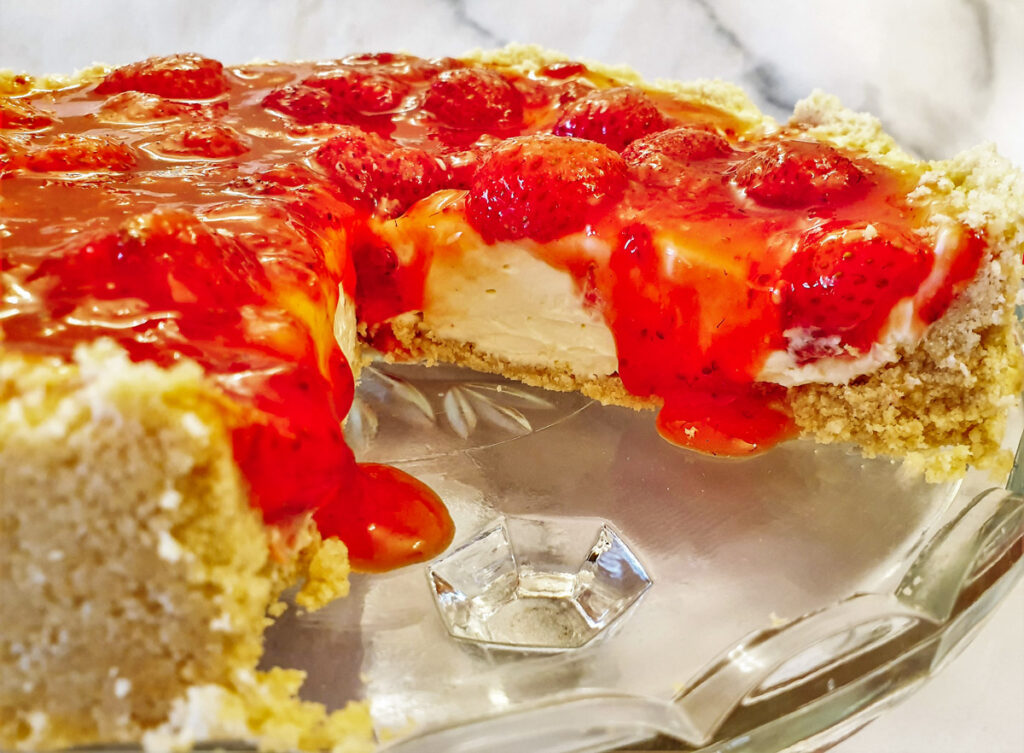 Closeup of no-bake strawberry cheesecake with oozing syrup.