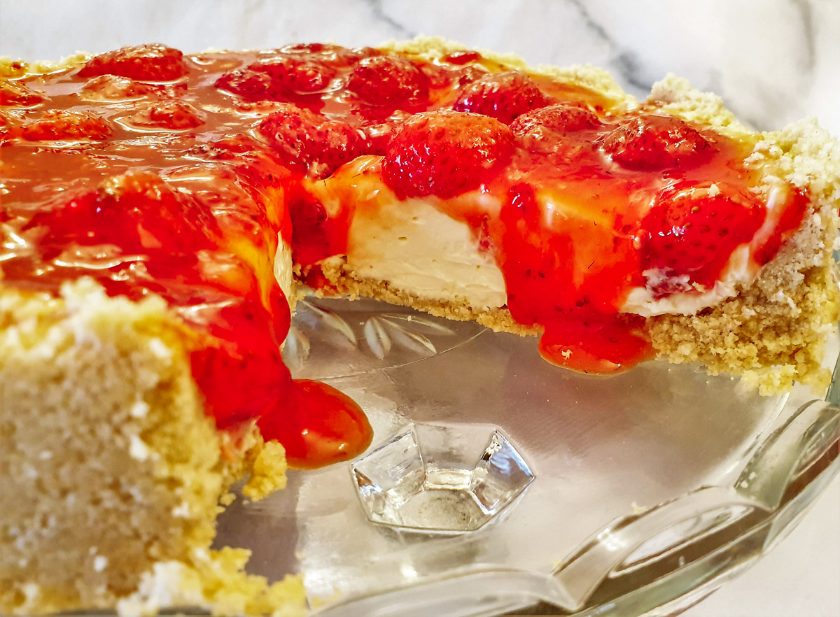 Closeup of no-bake strawberry cheesecake with oozing syrup.