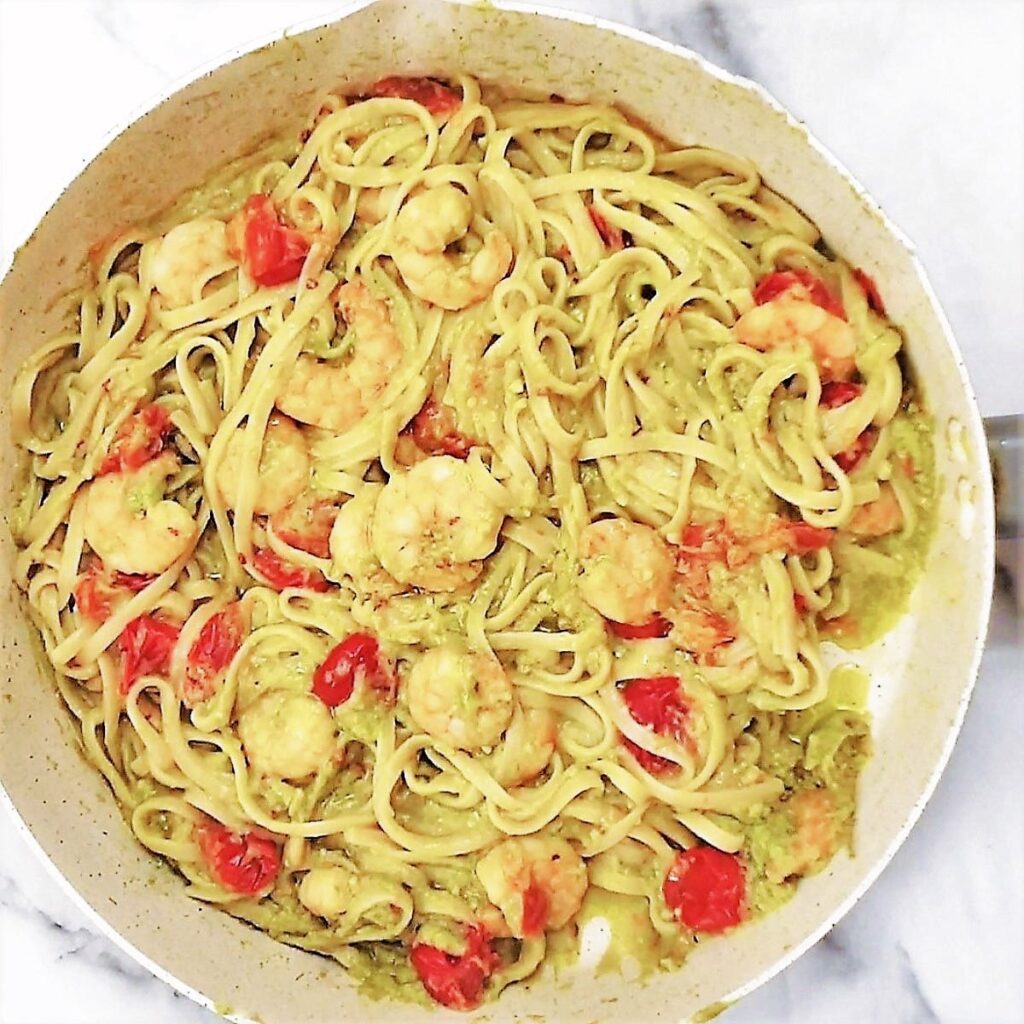 Avocado and shrimp linguine in a pan.