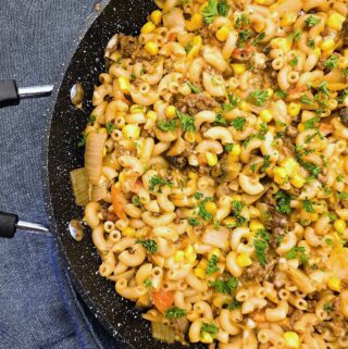 Closeup of a pan of noodles in a rich meaty sauce.