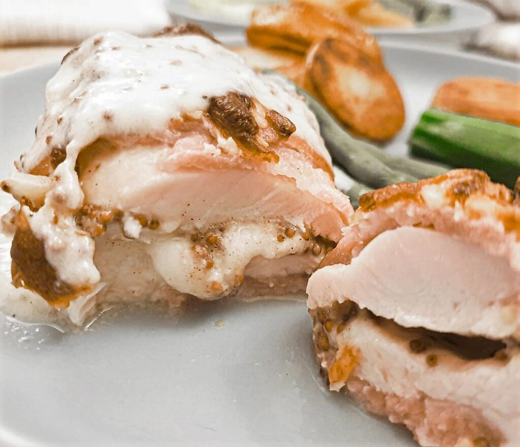 Cross-section of a cheesy bacon-wrapped chicken parcel.