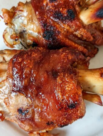 2 crispy pork knuckles on a plate.