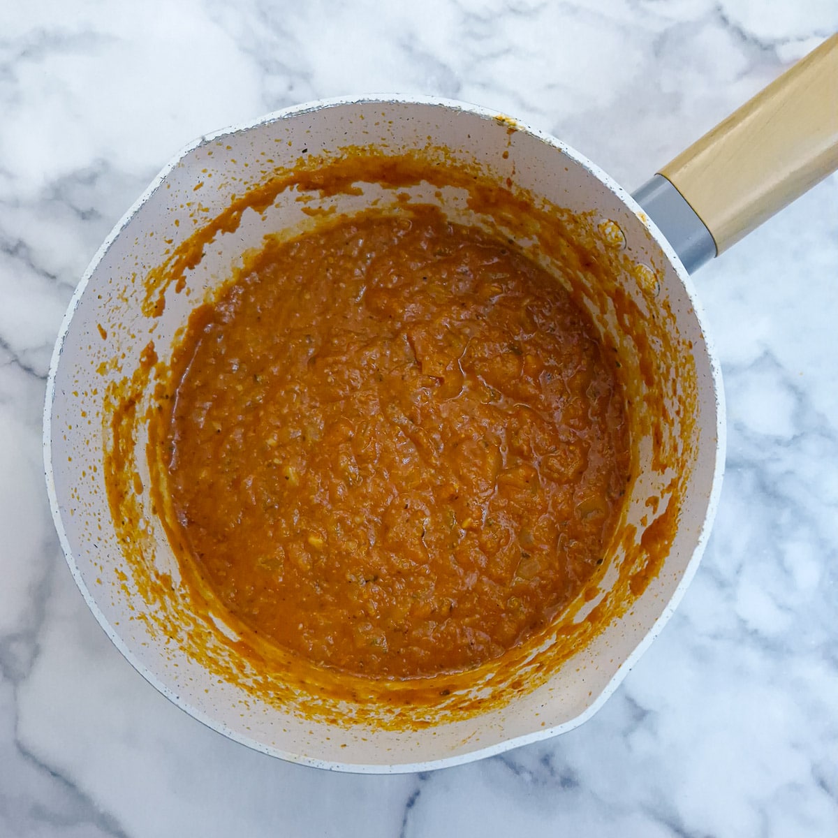 Step 5 - thickened marinara sauce in a saucepan.
