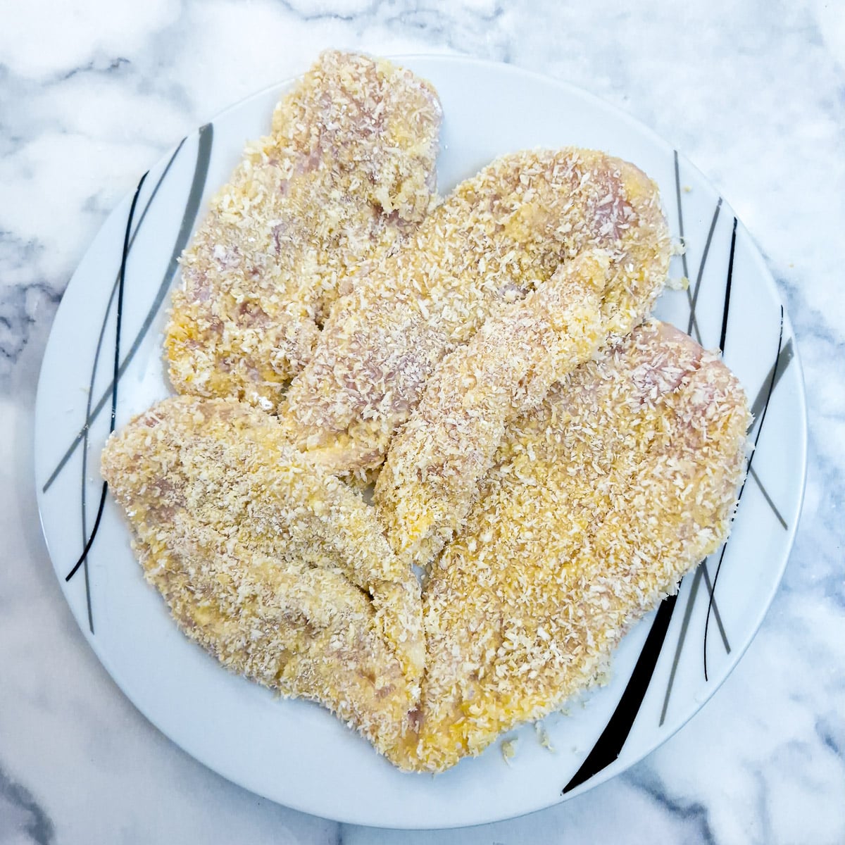 Step 2 - coated chicken on a plate ready to be chilled in the refrigerator.