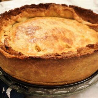 A baked beef and onion raised pie fresh from the oven.