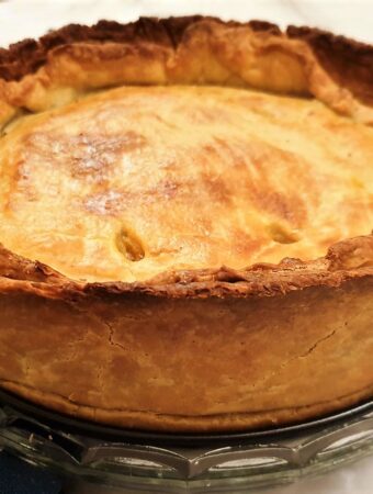 A baked beef and onion raised pie fresh from the oven.