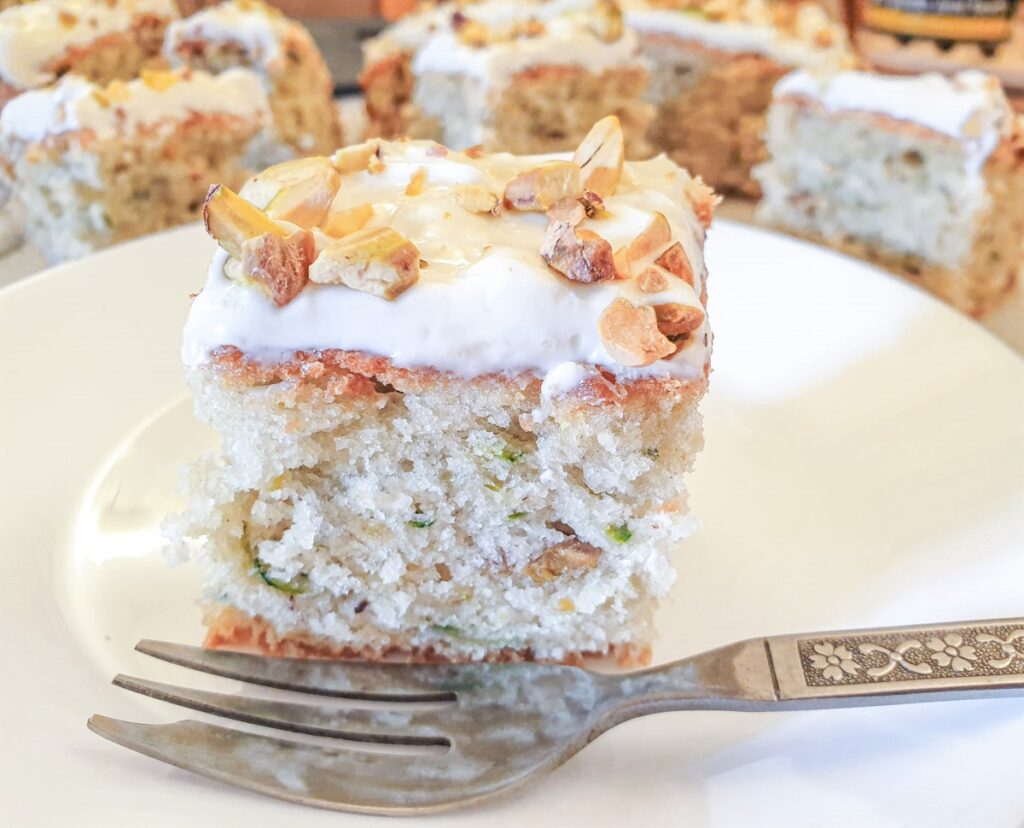 A slice of courgette cake on a plate, showing the texture of the cake.