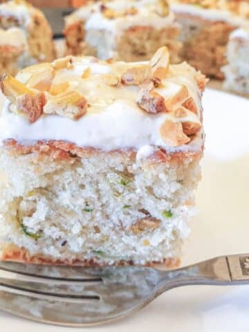 A slice of courgette cake on a plate, showing the texture of the cake.
