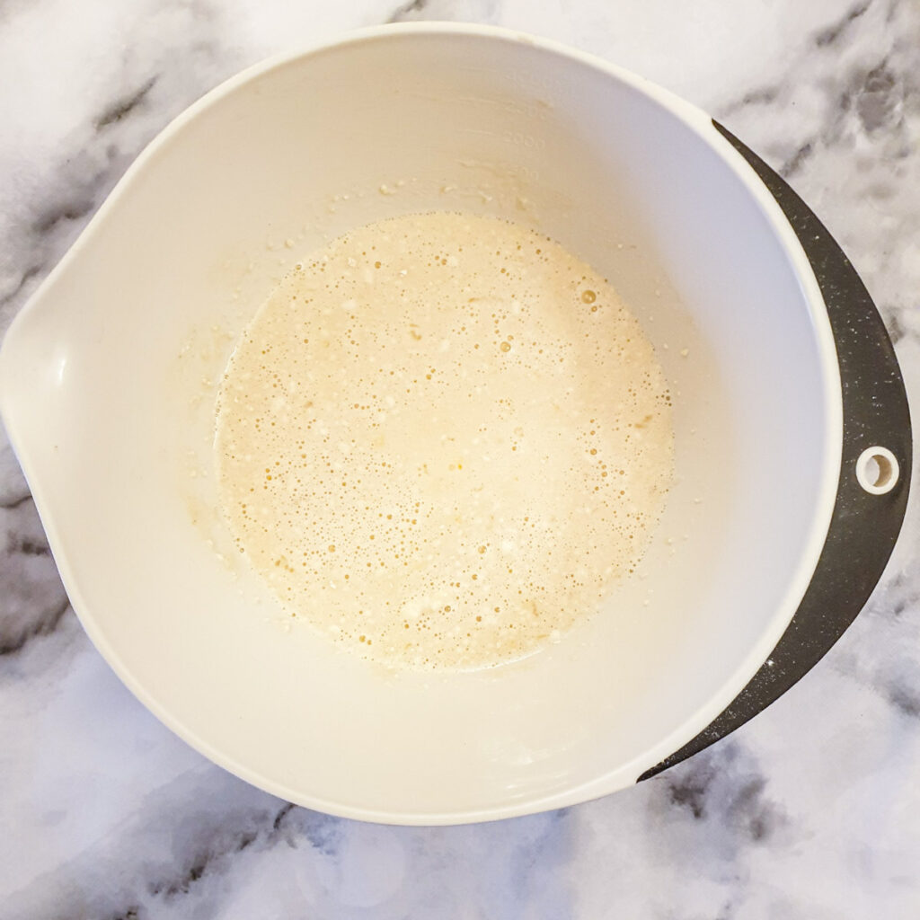 Flour, eggs, sugar, milk and vanilla essence mixed in a mixing bowl.