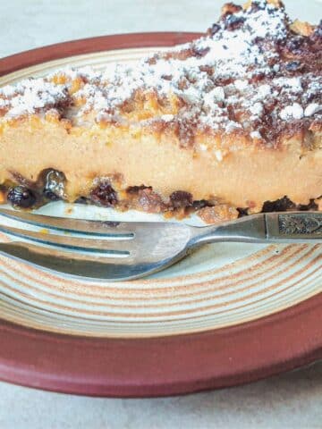 A slice of impossible Christmas tart on a plate with a dessert fork.