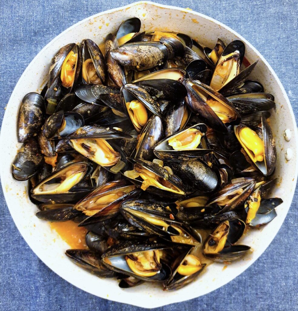 A pan of freshly cooked mussels that have opened.