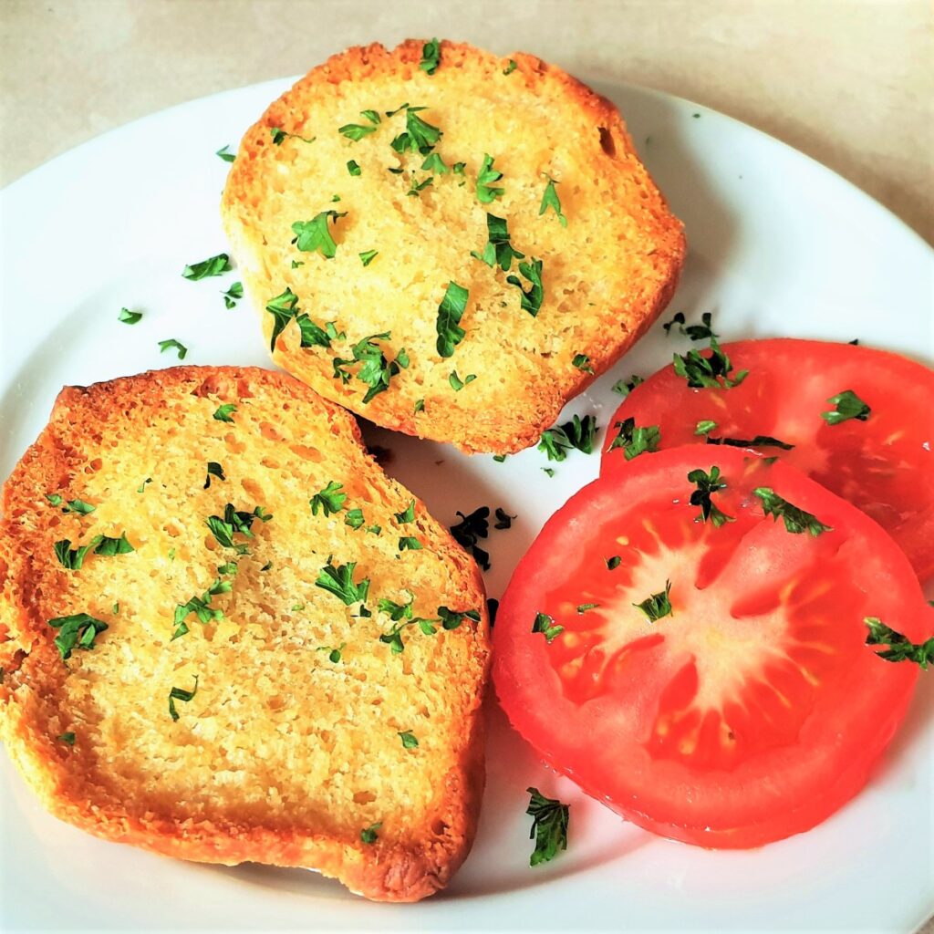 A crusty Portuguese rolls covered with garlic butter and toasted until brown and crispy.