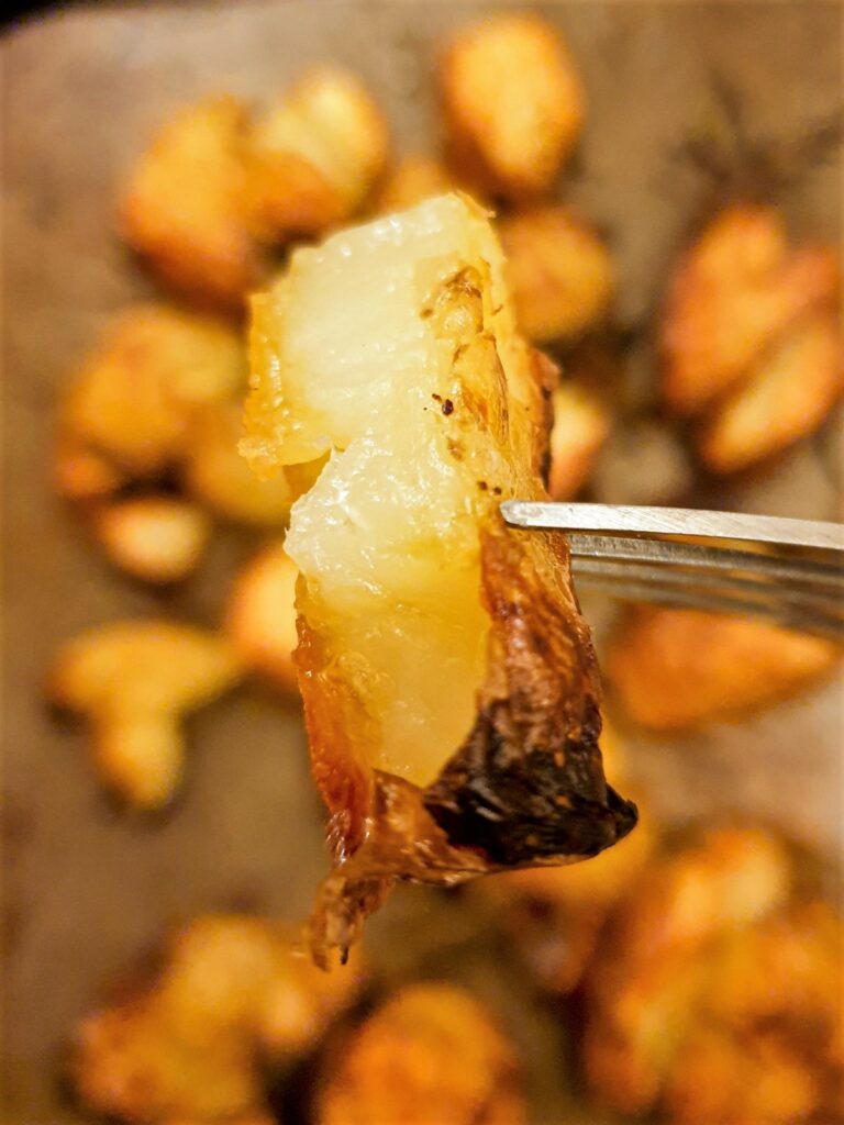 A piece of crispy potato on a fork.