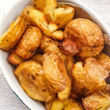 A dish of rosemary smashed potatoes.