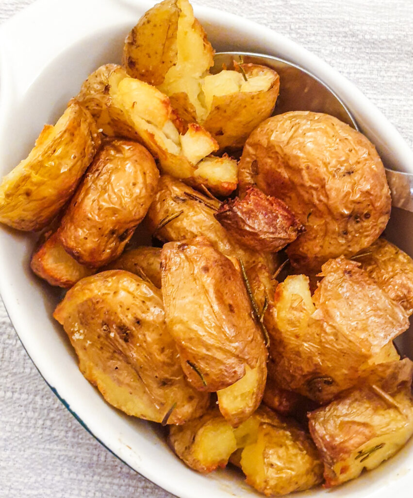 A dish of rosemary smashed potatoes.