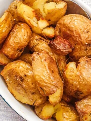 A dish of rosemary smashed potatoes.