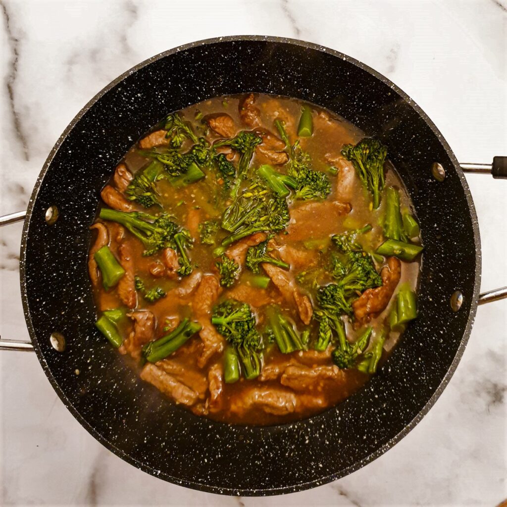 Beef and broccoli stir fry in a frying pan with the sauce.