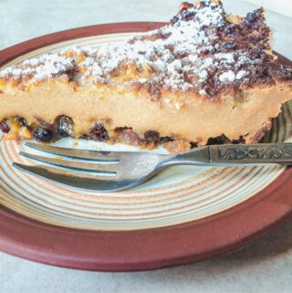 A slice of impossible Christmas pie on a plate with a dessert fork.