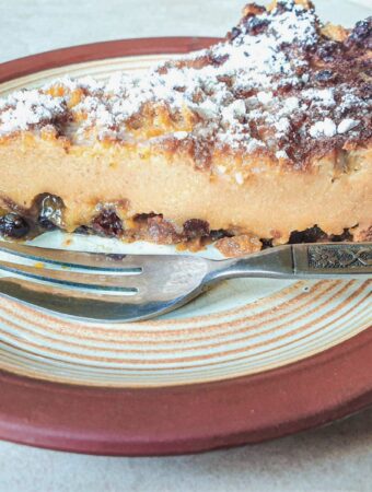A slice of impossible Christmas pie on a plate with a dessert fork.