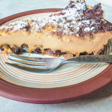 A slice of impossible Christmas pie on a plate with a dessert fork.