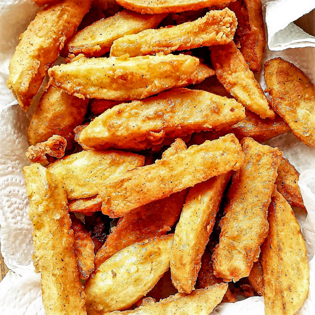 A pile of crispy French fries on a kitchen towel.