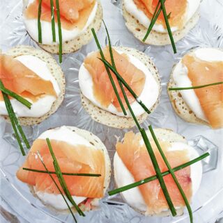 Closeup of blinis topped with creamy horesradish and smoked salmon.