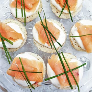 Closeup of blinis topped with creamy horesradish and smoked salmon.