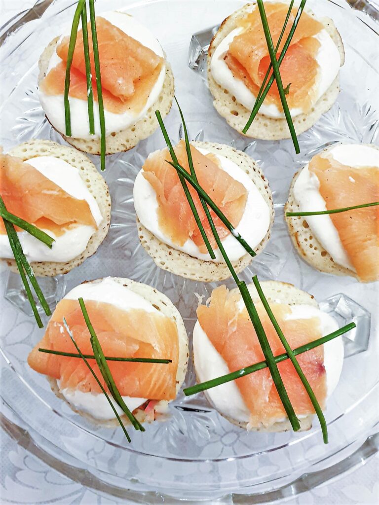 Closeup of blinis topped with creamy horesradish and smoked salmon.