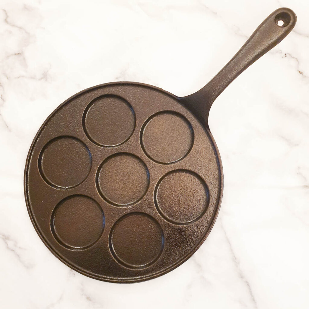 A blini pan with holes to hold the batter.