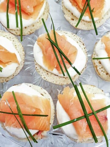 Closeup of blinis topped with creamy horesradish and smoked salmon.