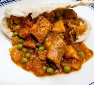 A plate of lamb curry in a pita bread.