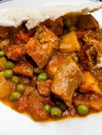 A plate of lamb curry in a pita bread.