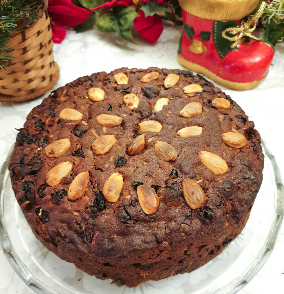 A plain unfrosted last-minute christmas cake decorated with blanched almonds.
