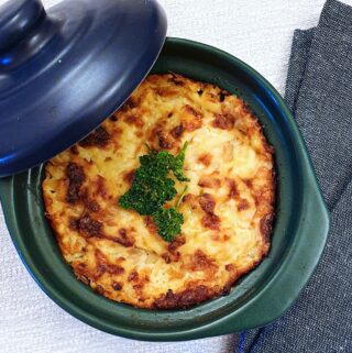 A small ramekin of potatoes Romanoff seen from above.