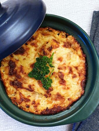 A small ramekin of potatoes Romanoff seen from above.